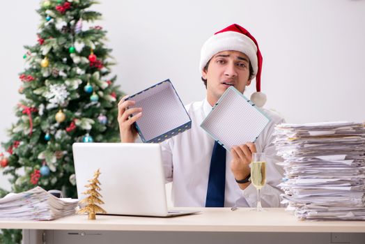 Young employee businessman in office christmas concept