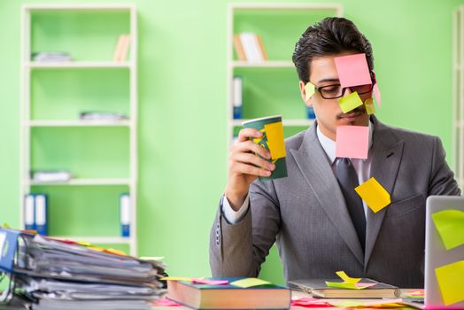 Businessman unhappy with many conflicting priorities sitting in the office 