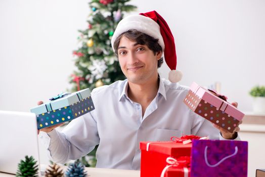 Young employee businessman in office christmas concept