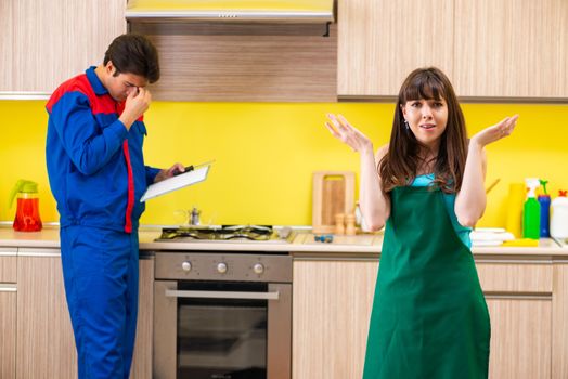 Woman with contractor at kitchen discussing repair