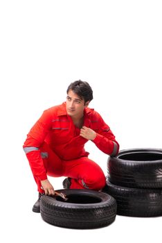 Young garage worker with tyre isolated on white