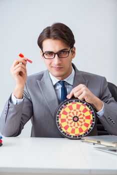 Businessman with dartboard sitting at the office