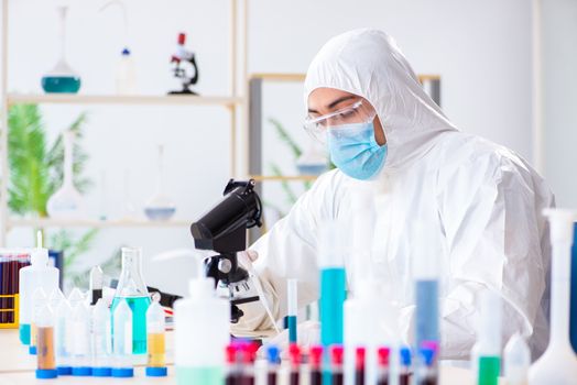 Young chemist student working in lab on chemicals