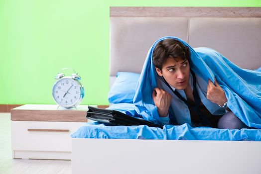 Employee in the bedroom being late for his job in time management concept