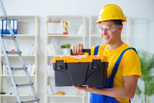 Young contractor doing repair works at office 