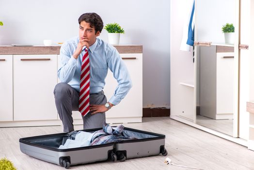 Young handsome businessman preparing for trip