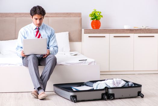 Young handsome businessman preparing for trip
