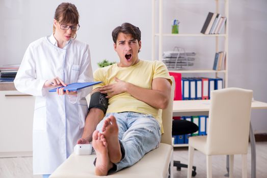 Young doctor checking patients blood pressure