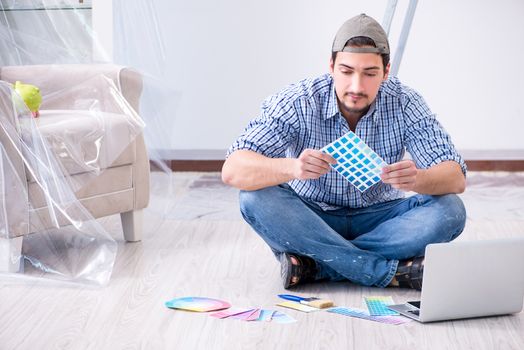 Young man contractor choosing color from rainbow 
