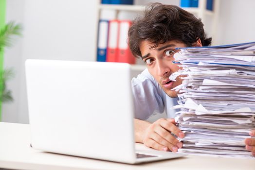 Overloaded busy employee with too much work and paperwork