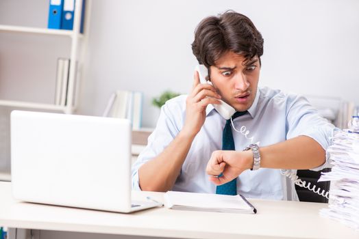 Overloaded busy employee with too much work and paperwork