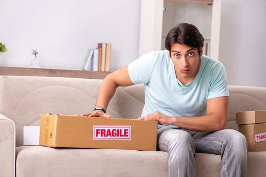 Man opening fragile parcel ordered from internet