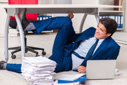 Tired exhausted businessman working overtime in office