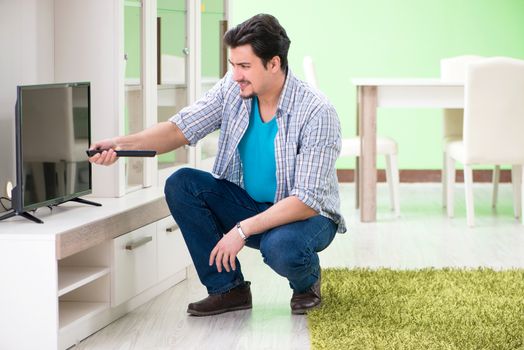 Young man husband repairing tv at home 