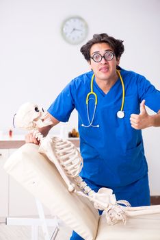 Funny doctor with skeleton in hospital