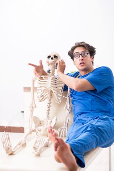 Funny doctor with skeleton in hospital