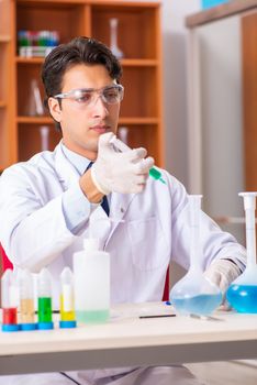 Young handsome biochemist working in the lab 