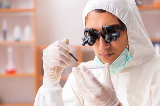 Young biochemist wearing protective suit working in the lab