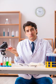 Young handsome biochemist working in the lab 