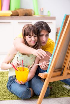 Young couple enjoying painting at home