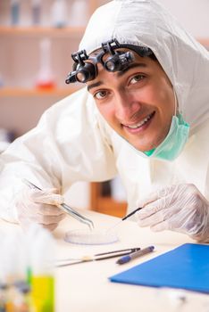 Young biochemist wearing protective suit working in the lab