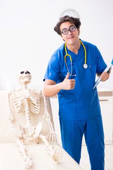 Funny doctor with skeleton in hospital