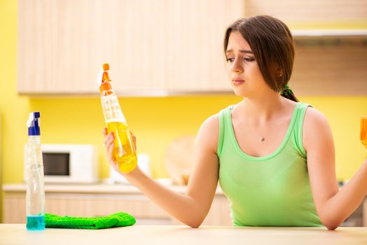 Young beatifull woman polishing table in the kitchen 