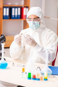 Young biochemist wearing protective suit working in the lab