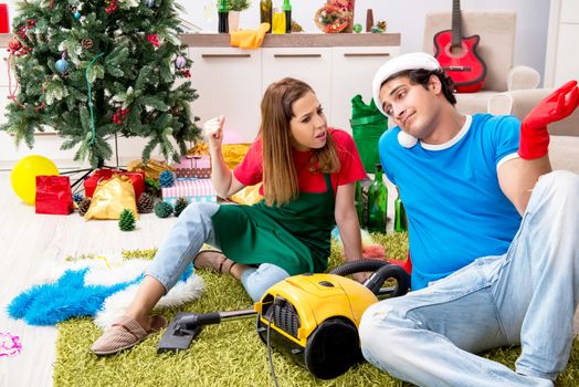Young family cleaning apartment after christmas party