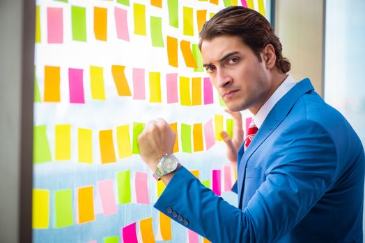 Young handsome employee with many conflicting priorities   