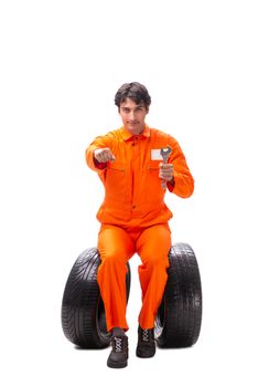 Young garage worker with tyre isolated on white