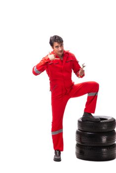 Young garage worker with tyre isolated on white