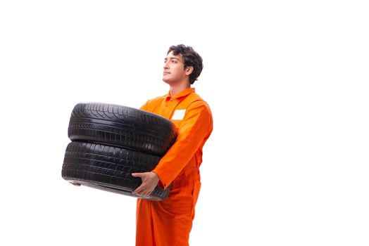 Young garage worker with tyre isolated on white
