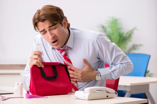 Man with first aid kit in the office