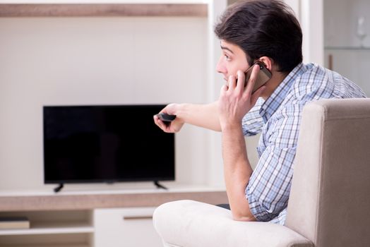 Young man watching tv at home