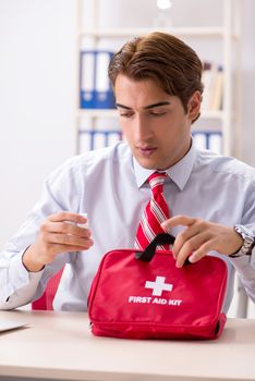 Man with first aid kit in the office