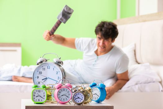 Young man having trouble waking up in early morning