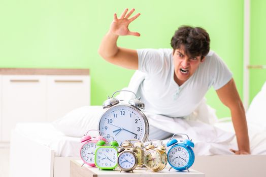 Young man having trouble waking up in early morning
