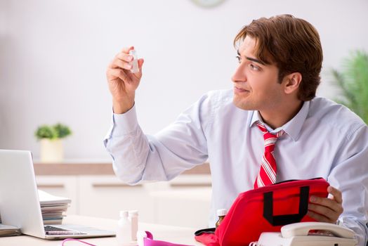 Man with first aid kit in the office
