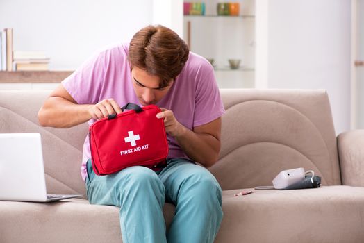 Sick man at home with first aid kit