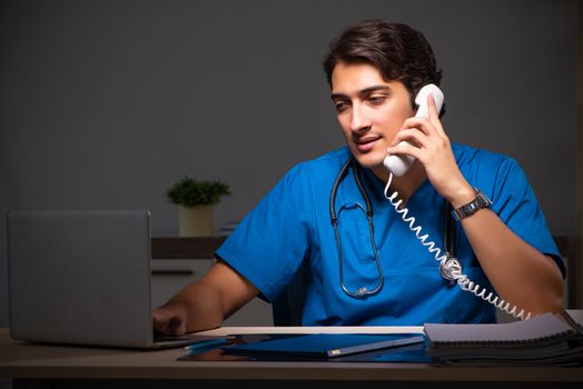 Young handsome doctor working night shift in hospital   