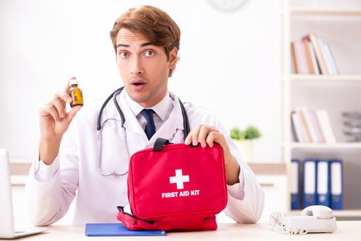 Young doctor with first aid kit in hospital