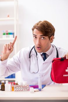 Young doctor with first aid kit in hospital