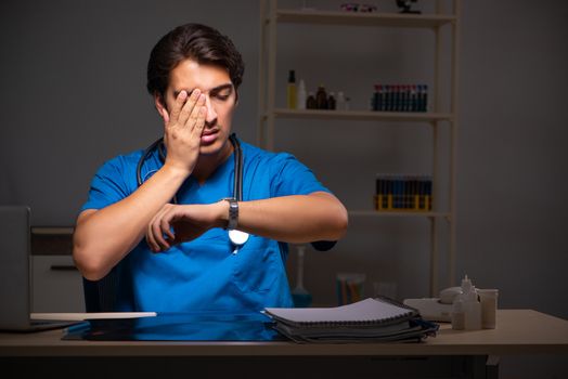 Young handsome doctor working night shift in hospital   