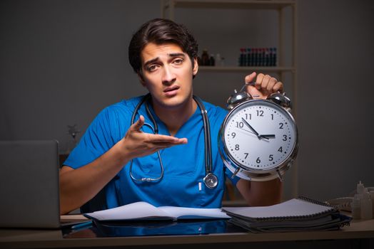 Young handsome doctor working night shift in hospital   