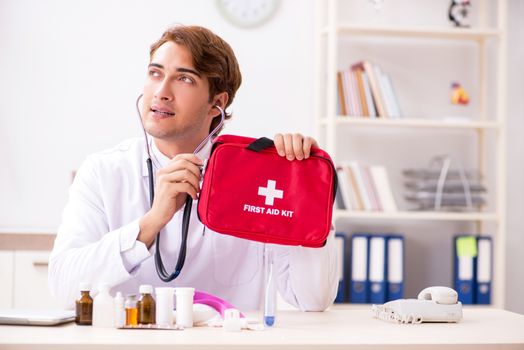 Young doctor with first aid kit in hospital