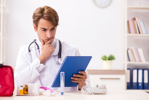 Young doctor with first aid kit in hospital