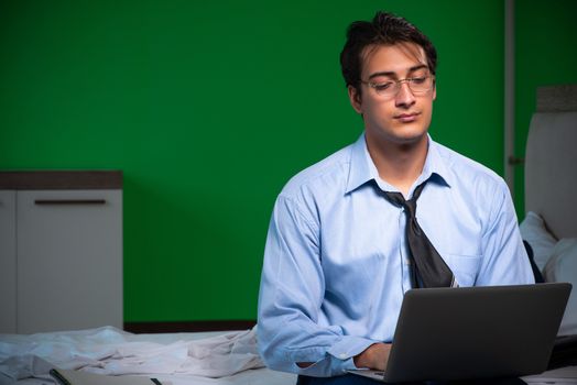 Young businessman under stress in the bedroom at night 