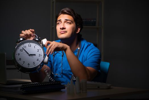 Young handsome doctor working night shift in hospital   