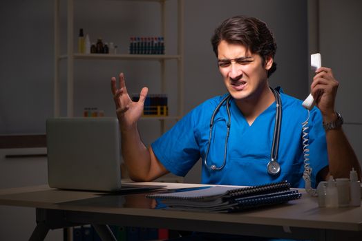 Young handsome doctor working night shift in hospital   